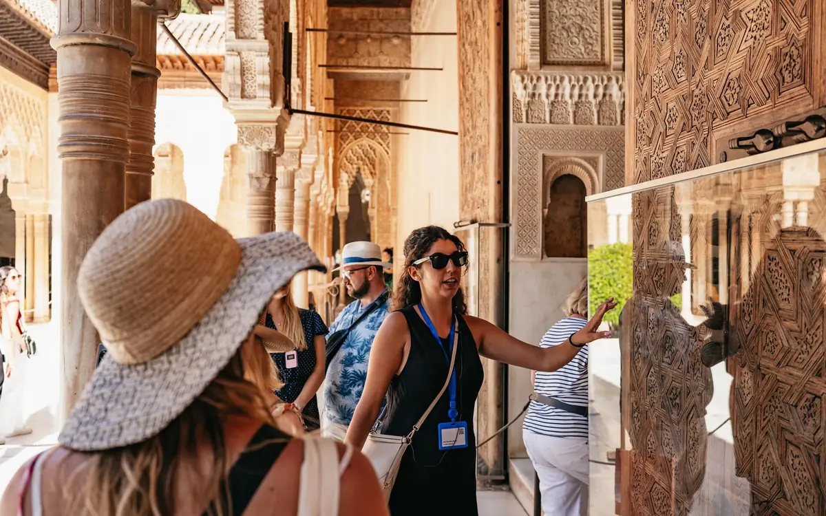 A guide with a group of visitors in a courtyard of the Alhambra